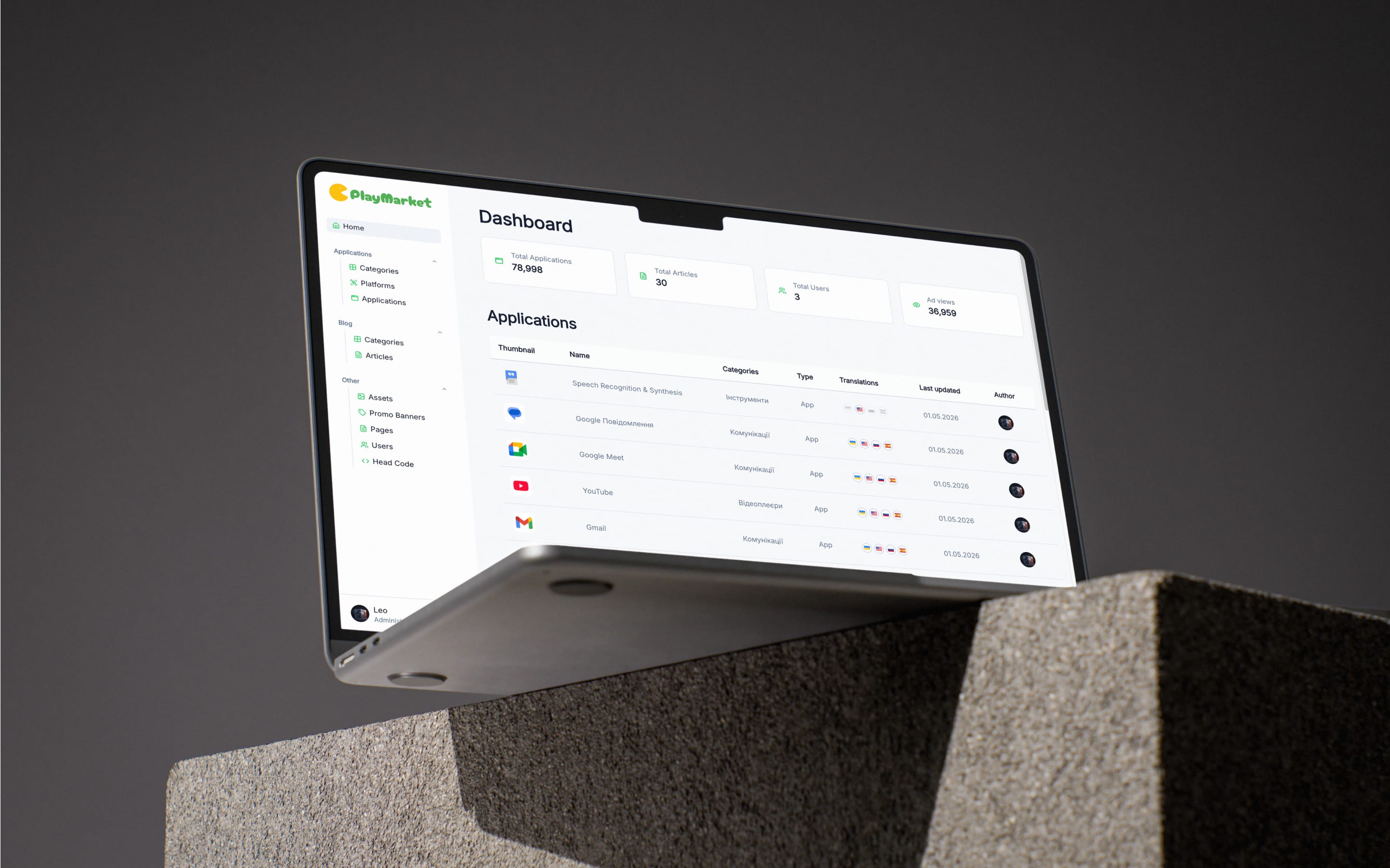 Laptop on a concrete block showing PlayMarket admin dashboard